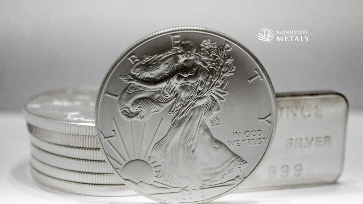 American Silver Eagle coin displayed in front of stacked silver rounds and a .999 fine silver bar, representing popular silver bullion products.