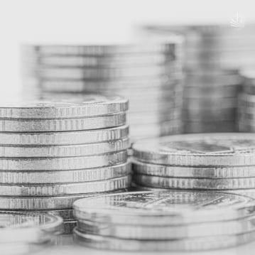 Black and white photo of multiple stacks of silver coins arranged at varying heights