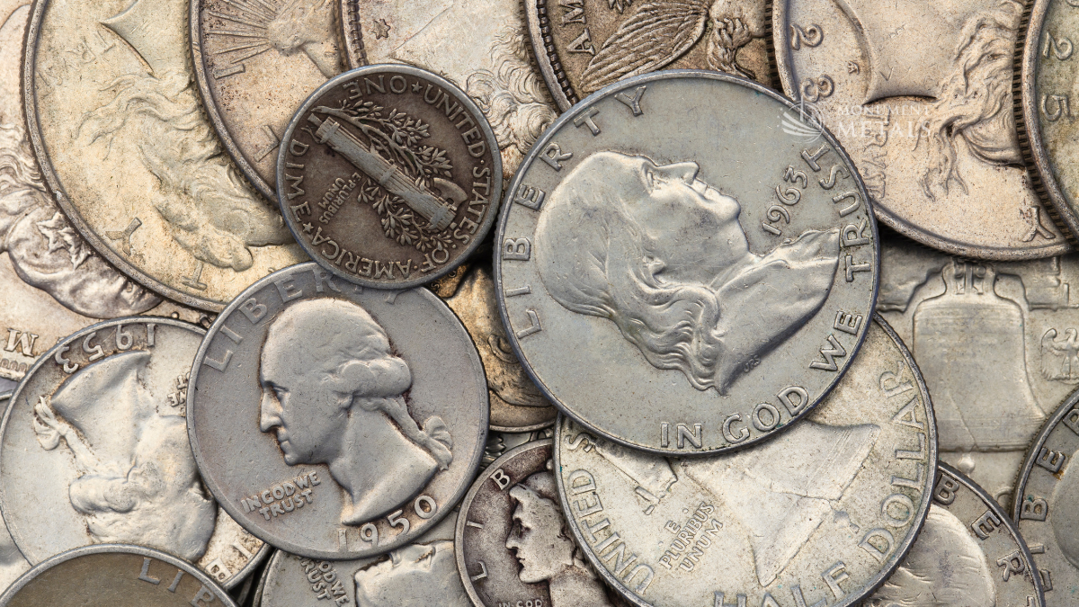 Assorted pre-1965 US junk silver coins including a 1950 Washington quarter, 1963 Franklin half dollar, and Mercury dime with Monument Metals logo