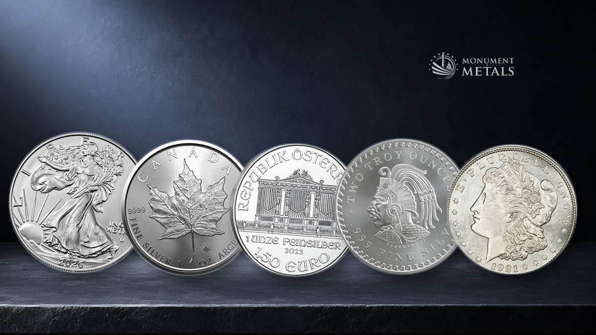 Popular silver coins and rounds including the American Silver Eagle, Canadian Silver Maple, Austrian Silver Philharmonic, a generic silver round, and a 1921 Morgan Dollar on a deep navy background with Monument Metals logo in top right hand corner.