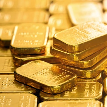 Stacked fine gold bullion bars stored in a secure precious metals depository