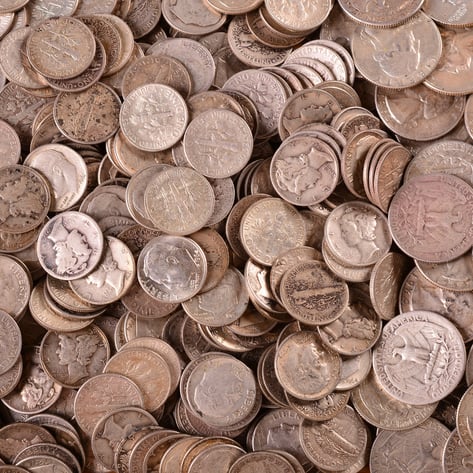 Large pile of pre-1965 US junk silver coins including Mercury dimes and Washington quarters with natural toning