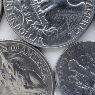 Close-up of pre-1965 Washington silver quarters showing obverse portrait and quarter dollar inscription
