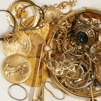 Pile of scrap gold jewelry, class rings, and gold coins ready to sell for cash in Frederick, MD