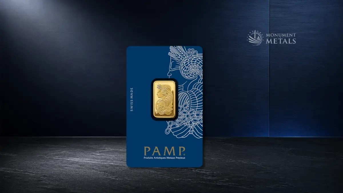 PAMP Suisse gold bar in blue assay packaging displayed on a dark stone surface.