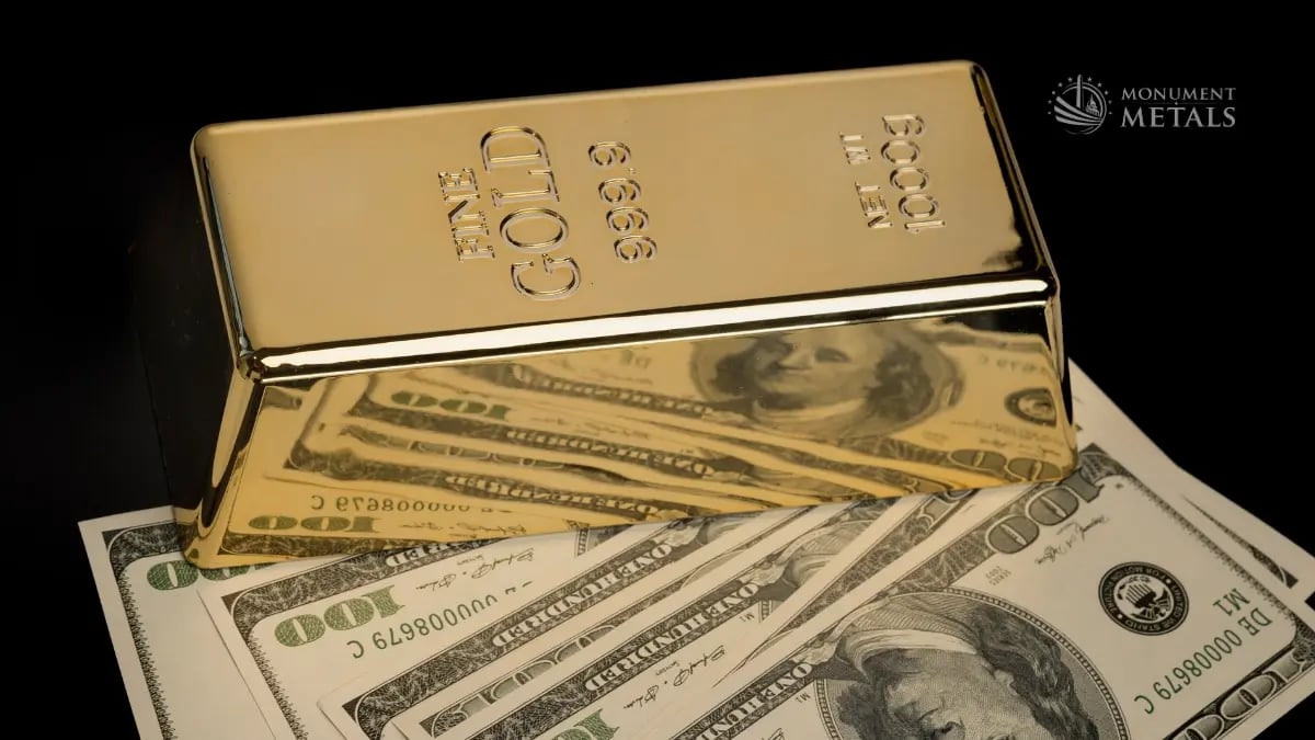 One-kilogram .9999 fine gold bar displayed over U.S. hundred-dollar bills against a black background.