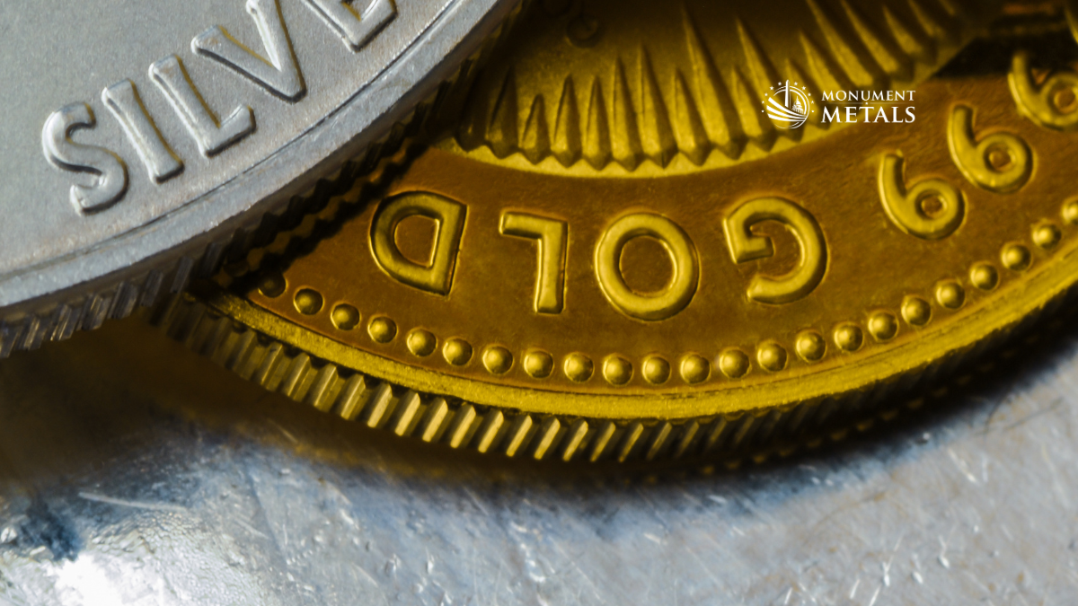 Macro close-up of gold and silver bullion coins stacked together, highlighting detailed edges and metal textures, with Monument Metals logo on the image.